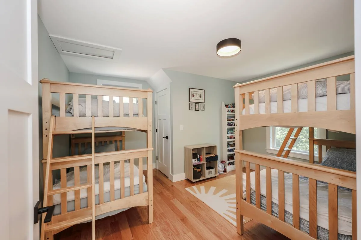 Natural wood bunk furniture in a bright professionally staged bedroom at Grateful Ledge