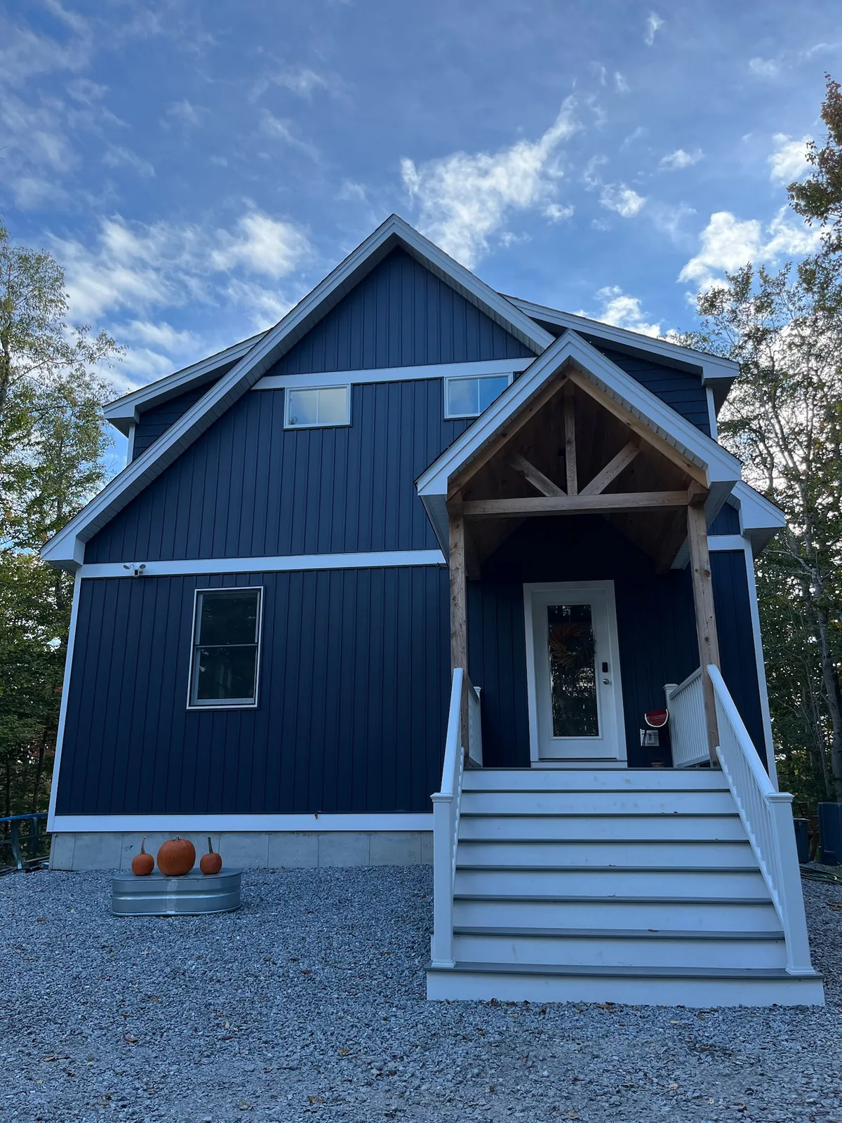Dark blue exterior of Grateful Ledge framed by trees